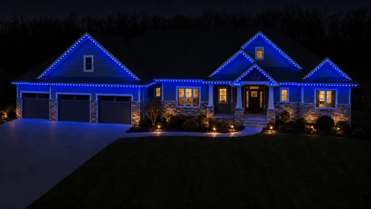 A home at night with permanent roofline lighting set to blue