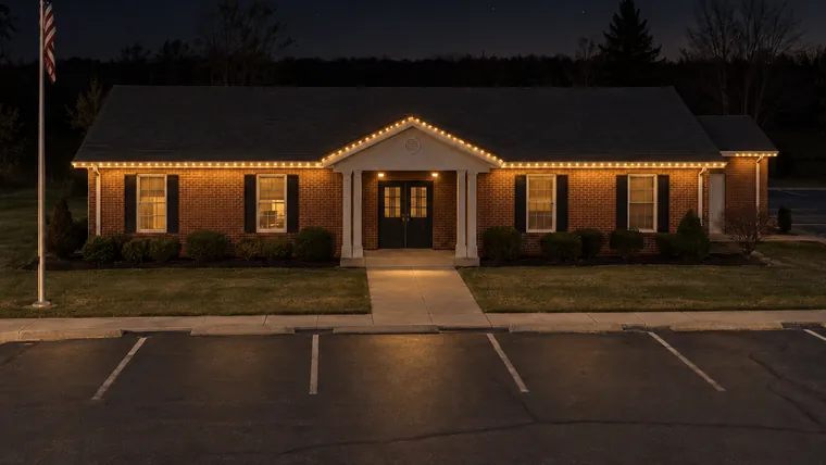 A township hall at night with permanent roofline lighting set to soft accent