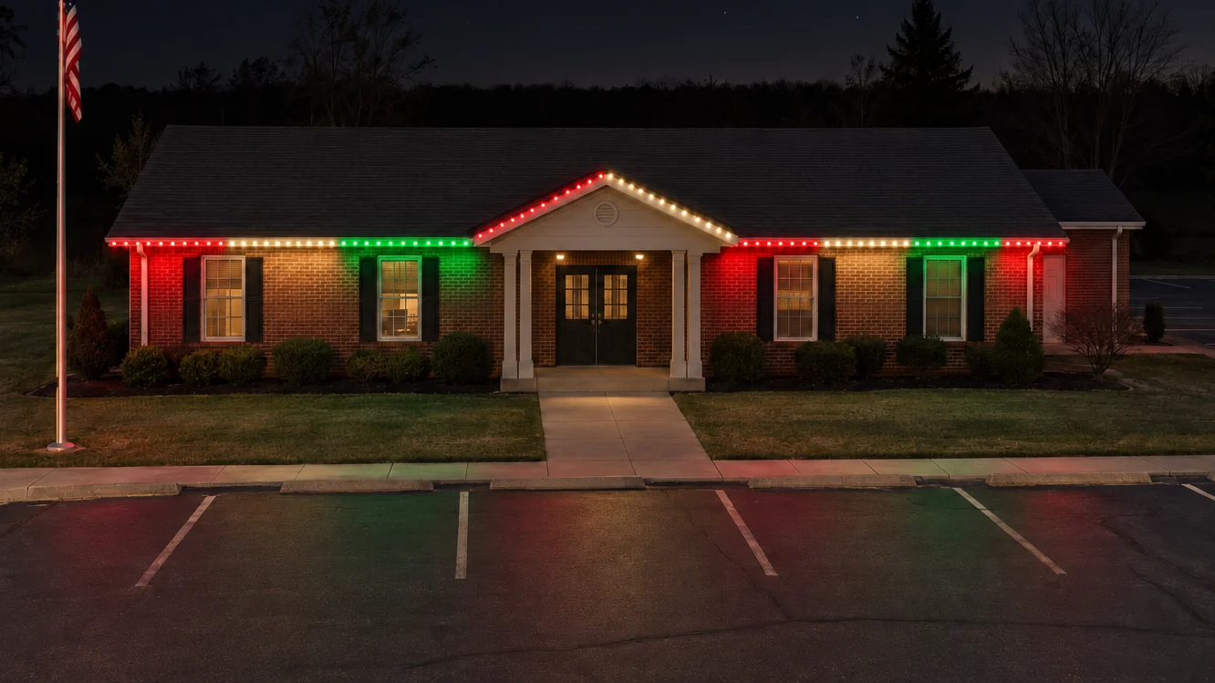 A commercial building at night with permanent lighting along the roofline