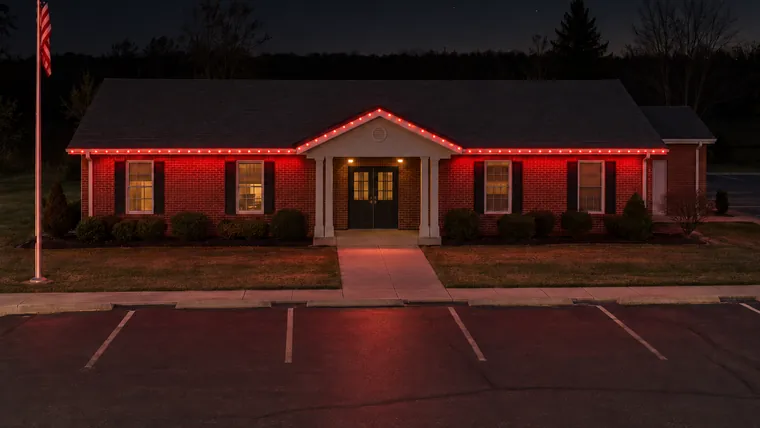 A township hall at night with permanent roofline lighting set to red